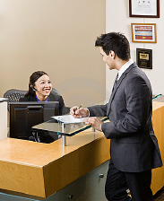 Homem do cumprimento do recepcionista na mesa dianteira